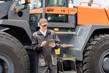 Sticker - Serviceman with digital tablet on a background of the tractor	