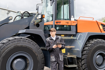 Poster - Serviceman with digital tablet on a background of the tractor	