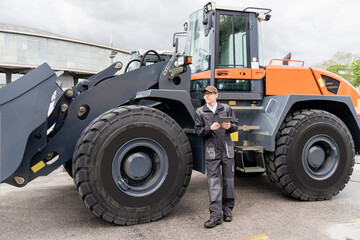 Poster - Serviceman with digital tablet on a background of the tractor	