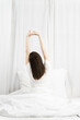 © NINENII - Rear view of a woman stretching her hands after wake up in the morning.