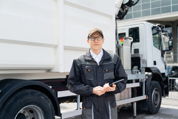 Poster - Manager with a digital tablet next to garbage truck.	