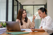 © Wasana - Two business women sit and discuss plans for a new project. Brainstorm and share ideas.