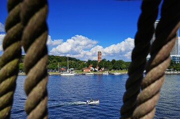 Wall Mural - Boat sailing on the Trave river surrounded by traditional buildings on a summer day in Germany