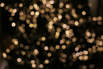 Background of bokeh lights, a blurred view of glittery yellow lights