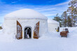 Two touristic igloos in the snow on a sunny day in Finland