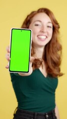 Green screen of the mobile held by a redheaded woman