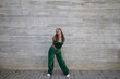 © @skuder_photographer - Latin woman, young and beautiful dancing modern dance on a background of gray cement in the street makes different expressions and postures. Concept dance, hip hop, dance, art, action, youth art.