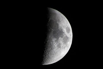 Wall Mural - closeup of a half-moon illuminating the dark night sky