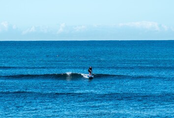 Sticker - Person stand-up paddleboarding in clear water with the horizon in the background.