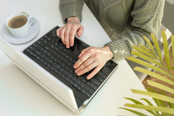 Woman working at home office hand on keyboard close up