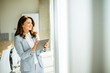 © BGStock72 - Young woman working on digital tablet by the office window