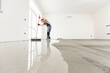 © Parilov - Leveling with mixture of cement for floors. Worker use screed concrete epoxy for level