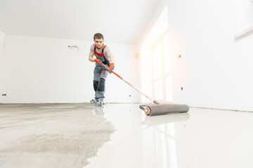 Master with needle roller for new screed concrete with mixture of cement for leveling for floors with sunlight, building renovation banner