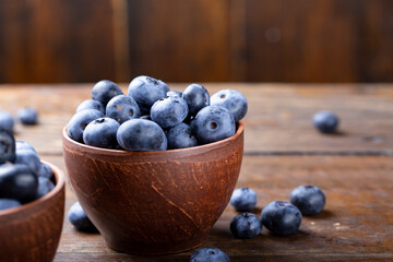 Wall Mural - Freshly picked blueberries in  bowl. Bilberry on wooden Background. Blueberry antioxidant. Concept for healthy eating and nutrition