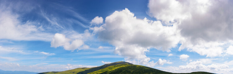 Wall Mural - gorgeous panorama of a blue sky with fluffy clouds. amazing cloudscape above the mountain range on a sunny weather in summer