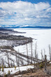 East shoreline of Yellowstone Lake looking south with snow- and ice-covered landscape of spring in Yellowstone National Park Wyoming.