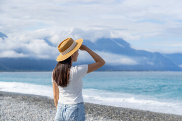 Poster - Woman with straw hat in the beach with clear blue sky