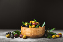 A Set Of Green, Red And Black Olives On A Black Marble Background. Different Types Of Olives In Bowls And Olive Oil With Fresh Olive Leaves. Delicacy.Mediterranean Kitchen. Copy Space.