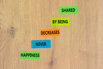 Wall Mural - Happiness symbol. Concept words Happiness never decreases by being shared on colored paper. Beautiful wooden table wooden background. Motivational Happiness concept. Copy space.
