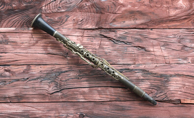 Wall Mural - clarinet on red wooden table