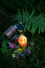 Poster - Burning candle, magic potion bottles, flowers on dark forest natural background. Magic ritual, Witchcraft, spiritual practice. pagan, Wiccan, Slavic traditions. esoteric ritual for Midsummer, Litha.