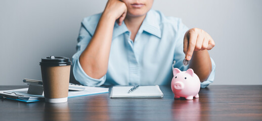 Wall Mural - Business asian woman hand put coins in piggy bank on wood table background, saving money wealth and financial concept, finance, investment, Financial planning.Financial planning deposit for retirement