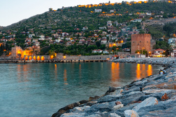 Wall Mural - Illuminated Mediterranean coast of Alanya, Antalya Province, Turkey. View of Red Tower and Tersane dockyard in evening.