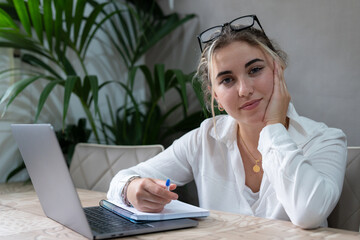 Portrait of serious millennial caucasian female student sit at desk at home study online on laptop. Professional young woman use computer take distant course or training. Education concept..