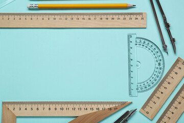 Wall Mural - Flat lay composition with different rulers and protractor on turquoise background. Space for text