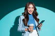 smiling attractive confident asian female business woman wear stylish casual suit standing look at camera hand hold coffee smartphone thinking strategy ideas business woman studio shot blue background