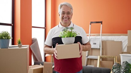 Poster - Middle age man with grey hair smiling confident holding package at new home