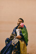 © Scopio - Man sitting in traditional clothes holding pink flowers
