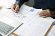 © Lek - Asian businessman and financial expert analyzing investment plan, business report graph and finance budget chart in the office. Concept of finance economy, and marketing research