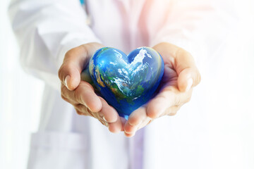 Hands hold Earth ball in heart shape on Doctor hands for World Health Day content and copy space.Elements of this image furnished by NASA