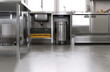 © Sue Tansirimas - New, clean gray concrete resin vinyl floor in commercial, professional bakery kitchen, stainless steel cabinet, sink, trash bin, machine, equipment. Industrial interior design background 3D