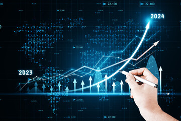 2023 and 2024 years investing and sale planning concept with businessman hand with pen working with financial chart hologram on digital screen with arrow, on dark blue background with world map