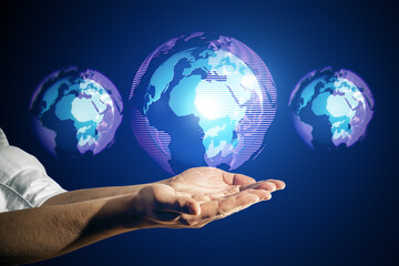 Wall Mural - Close up of male hand holding glowing digital globe hologram on dark background. Digital world, global hacking protection and hud concept.