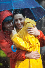 Canvas Print - Happy couple hugging under umbrella in rain