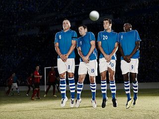 Soccer players jumping on field