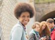 Woman smiling by chain link fence with friends in background