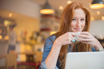 Wall Mural - Woman using laptop in cafe