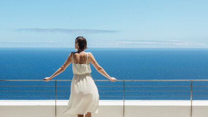 Woman looking at ocean from balcony