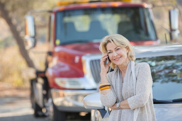 Wall Mural - Woman talking on cell phone near tow truck at roadside