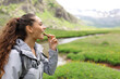 © Antonioguillem - Hiker eating cereal bar in a valley