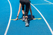 Symbolbild Leichtathletik: Junge Frau vor dem Start eines Wettlaufs