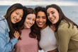 © PintoArt - Diversity, multi-ethnic beauty concept. Four beautiful smiling ladies of different races, Hispanic, Asian and Caucasian, natural, posing on the sea background
