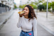© PintoArt - overweight woman eating pizza in the city, cuvy hispanic girl happy while eating rich italian food