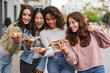 © PintoArt - multiracial female friends eating pizza in the city