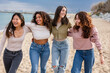 © PintoArt - group of diverse women on the beach walking on the sand happy, having fun on the beach
