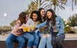 © PintoArt - group of multiracial female friends drinking alcohol at beach party